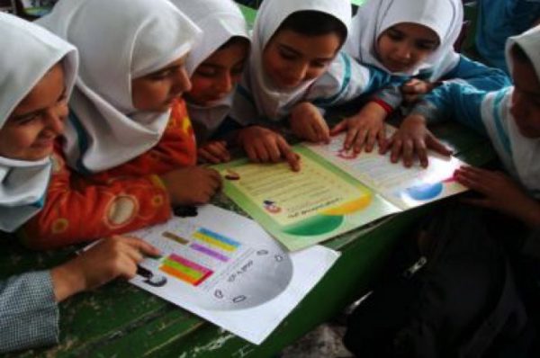 Six Iranian girls looking at educational material